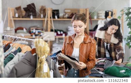 Young woman choosing gloves against the background of a buyer Young woman choosing gloves against the background of a buyer 131622348