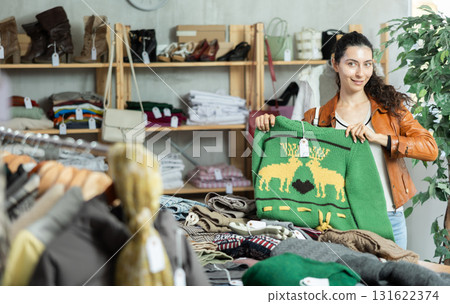 Young woman choosing sweater in clothing store Young woman choosing sweater in clothing store 131622374