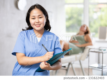 Asian professional cosmetologist advertising facial procedure to patients Asian professional cosmetologist advertising facial procedure to patients 131622403