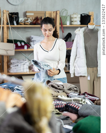 Young woman choosing jeans in clothing store Young woman choosing jeans in clothing store 131622417