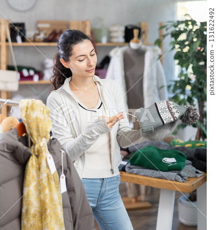 Young woman choosing hat in clothing store 131622492