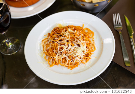 Spaghetti bolognese with cheese served on platter 131622543