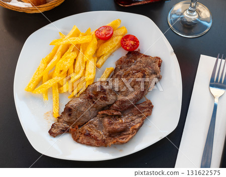 Grilled beef filet steak with side dish of potatoes and tomatoes Grilled beef filet steak with side dish of potatoes and tomatoes 131622575