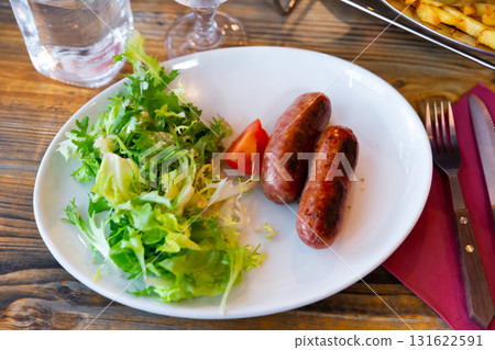 Sausages served with potatoes and salad Sausages served with potatoes and salad 131622591