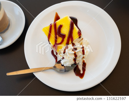 Slice of lemon biscuit cheesecake piece of delicate vanilla dessert with cream decorated with chocolate topping 131622597