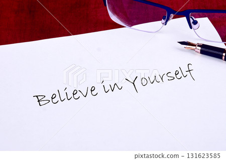 The words Believe in Yourself are hand-written on bright white paper Near the sentiment sits a fountain pen and a pair of spectacles, ready to forge ahead The words Believe in Yourself are hand-written on bright white paper Near the sentiment sits a fountain pen and a pair of spectacles, ready to forge ahead 131623585