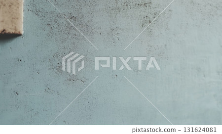 Surface texture of a weathered blue wall with signs of age and wear 131624081