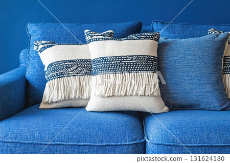 Cozy blue couch adorned with decorative pillows for stylish living room 131624180