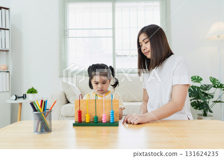 Child Learning with Abacus in Bright Room, Engaging Activities for Cognitive Development, Educator Assisting Young Learner at Home Child Learning with Abacus in Bright Room, Engaging Activities for Cognitive Development, Educator Assisting Young Learner at Home 131624235