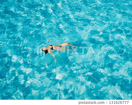Woman swimming in clear blue sea on sunny day. Drone view Woman swimming in clear blue sea on sunny day. Drone view 131626777