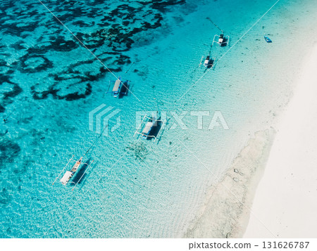 Clear ocean and white sand beach with balinese fishing boats in tropical island. Aerial view. Clear ocean and white sand beach with balinese fishing boats in tropical island. Aerial view. 131626787