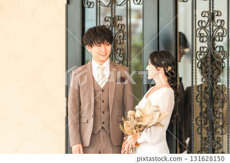 Bride and groom in front of the door to the wedding reception hall 131628150
