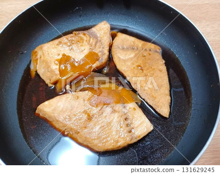Braised swordfish fillets in a frying pan 131629245