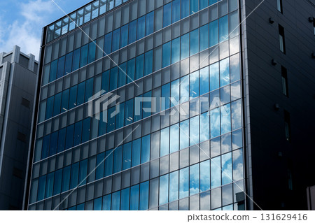 A blue sky reflected in the window of the building 131629416