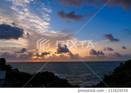 南紀勝浦市熊野灘的黎明：陽光透過雲層，美麗的早晨天空從金色變成鈷藍色。 131629550