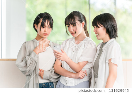 A group of elementary and junior high school girls are surprised by their smartphones 131629945