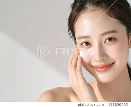 年輕女子在臉上塗抹保濕霜 年輕女子在臉上塗抹保濕霜 131630495