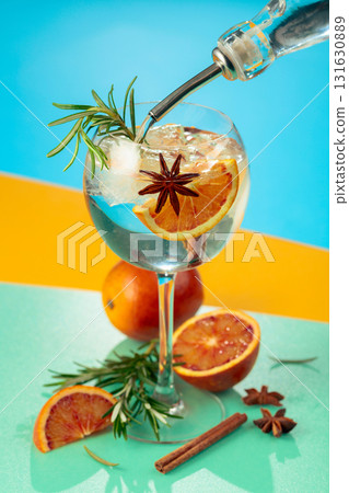 Summer cocktail with gin, tonic, blood orange, cinnamon, anise, and rosemary. Summer cocktail with gin, tonic, blood orange, cinnamon, anise, and rosemary. 131630889