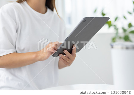 Close-up of a woman's hands operating a tablet 131630948