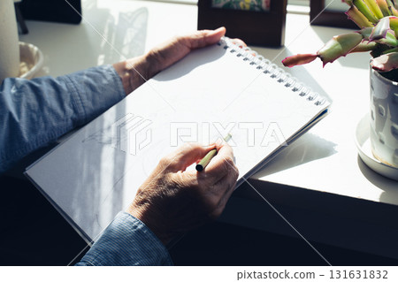 Hands of a senior woman drawing a picture Hands of a senior woman drawing a picture 131631832