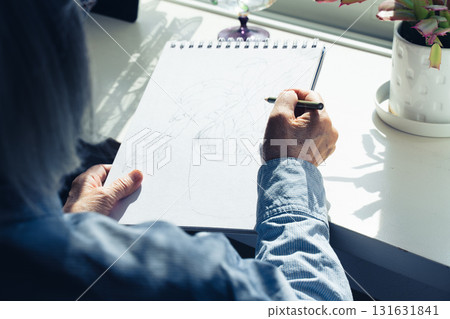 Hands of a senior woman drawing a picture 131631841