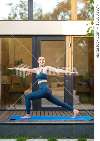 Slim young woman doing lunges on a yoga mat 131631977