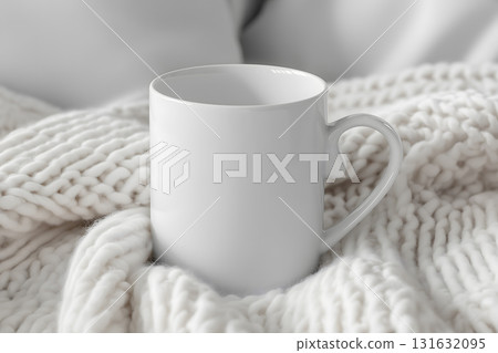White mug is sitting on a white blanket 131632095