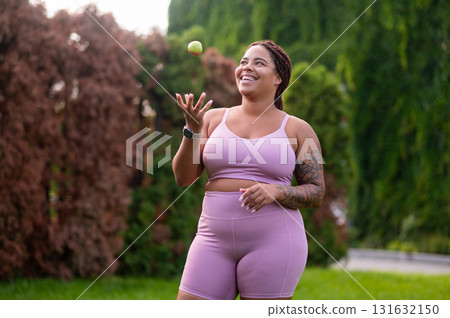 Happy woman in pink standing at the lawn and looking positive Happy woman in pink standing at the lawn and looking positive 131632150