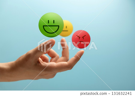 Hand balancing Colorful emotional faces Ball, symbolizing mental health and emotional self-regulation through balancing positive and negative emotions 131632241
