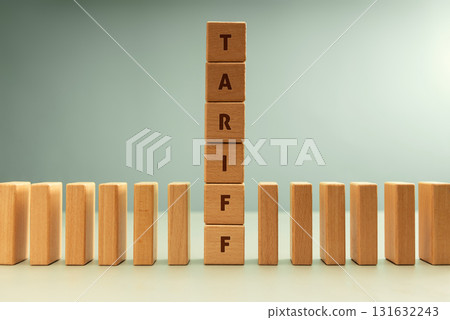 Dominoes row with vertical stack labeled TARIFF, Trade barriers affect global economies in domino impact 131632243