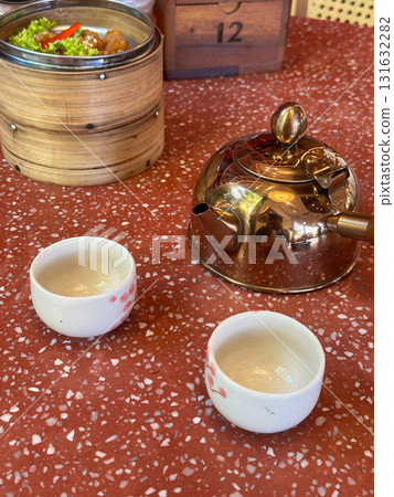 tea set with pot and dim sum tray on red cement table 131632282