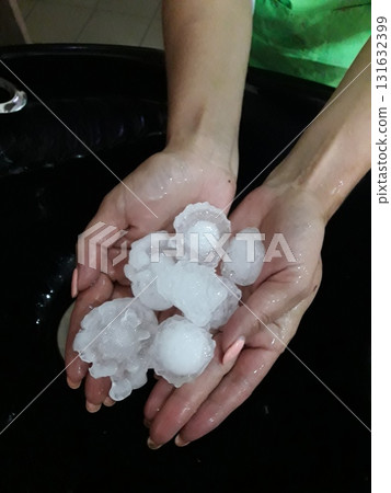Large ice hail in female hands. Large ice hail in female hands. 131632399