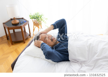 中年男子抱著頭躺在床上 131632525
