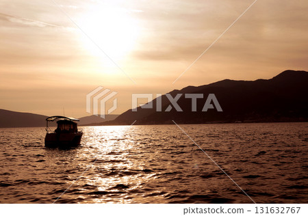 Beautiful view of the sea bay, Tivat, Montenegro. Yacht and mountains off the coast of Tivat at sunset, Adriatic Sea. Photo toned in yellow color. Topic of summer vacation, travel, tours 131632767