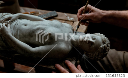 A person's hand carving a stone statue. Stone carving, ancient art, craftsmanship, skill, dedication A person's hand carving a stone statue. Stone carving, ancient art, craftsmanship, skill, dedication 131632823