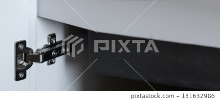 cabinet hinge, ideal for furniture, hardware, or interior design project visuals. a modern kitchen cabinet, highlighting premium hinge and clever storage accessories. white copy space banner cabinet hinge, ideal for furniture, hardware, or interior design project visuals. a modern kitchen cabinet, highlighting premium hinge and clever storage accessories. white copy space banner 131632986