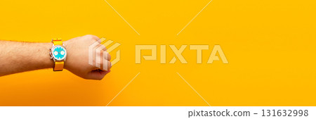 A striking ad banner showcasing a man hand wearing a stylish watch, set against a bold, energetic yellow background. time management ad creative yellow 131632998