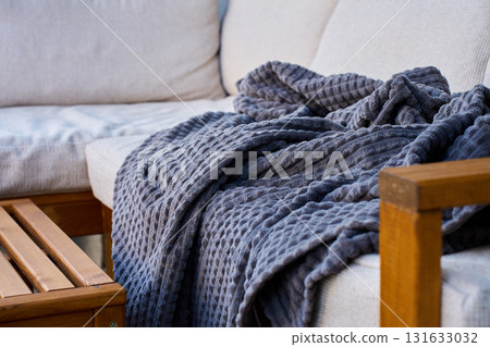 Wooden outdoor sofa with blanket on patio terrace 131633032