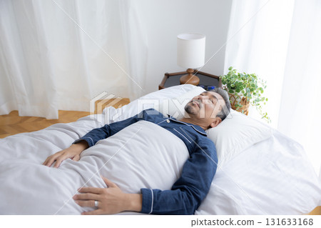 Bedroom: Middle-aged man sleeping soundly Bedroom: Middle-aged man sleeping soundly 131633168