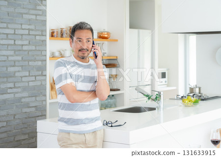 Middle-aged man using smartphone in the kitchen 131633915