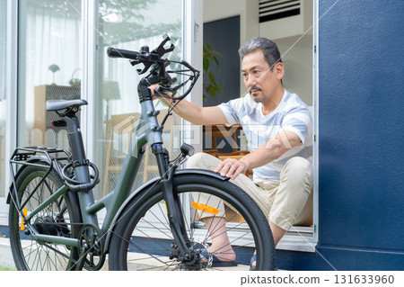 一名中年男子在花園裡保養電動自行車 131633960