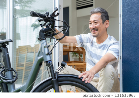 一名中年男子在花園裡保養電動自行車 131633963