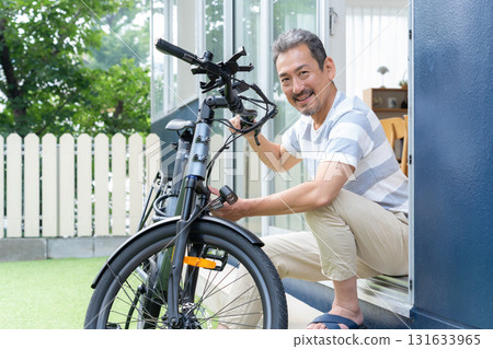 一名中年男子在花園裡保養電動自行車 131633965