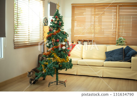 Festive Christmas tree adorned with ornaments in a cozy living room 131634790