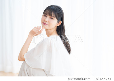 Middle-aged woman doing skin care in the living room Middle-aged woman doing skin care in the living room 131635734
