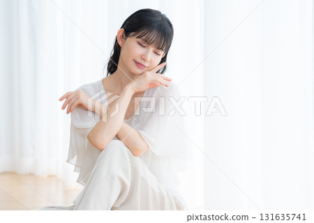 Middle-aged woman doing skin care in the living room 131635741