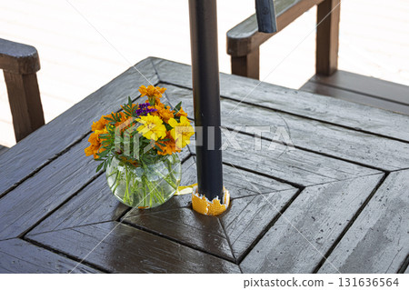 Flowers on a table on a wooden deck Flowers on a table on a wooden deck 131636564