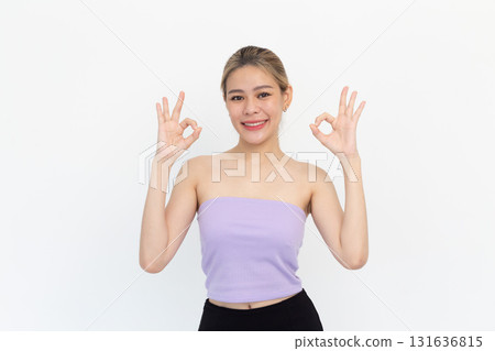 Portrait of Happy asian young woman smiling against made finger thumbs up OK gesture on white background Portrait of Happy asian young woman smiling against made finger thumbs up OK gesture on white background 131636815