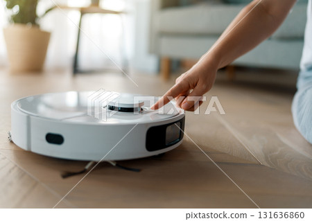 White robotic vacuum cleaner on wooden floor White robotic vacuum cleaner on wooden floor 131636860