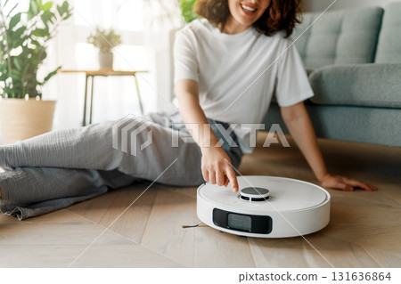 White robotic vacuum cleaner on wooden floor White robotic vacuum cleaner on wooden floor 131636864